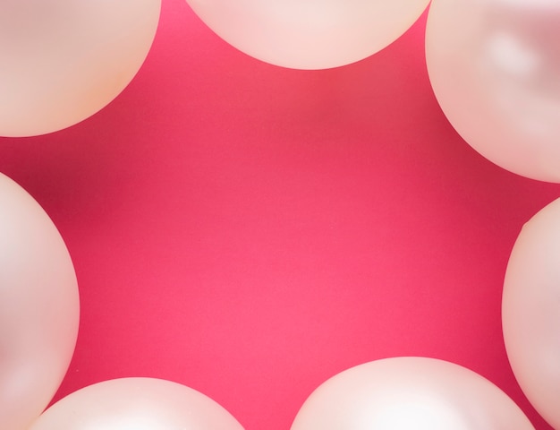 Flat lay frame with balloons and pink background