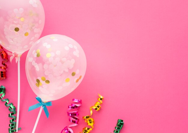 Flat lay frame with confetti and pink background