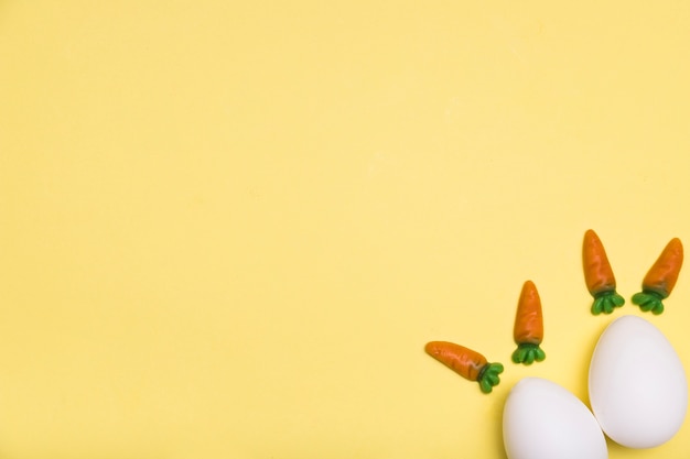 Flat lay frame with eggs and little carrots