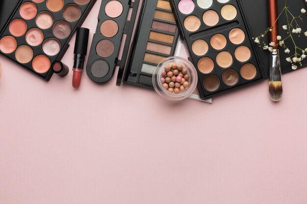 Flat lay frame with lipstick and make-up palettes