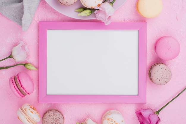 Free photo flat lay of frame with macarons and roses