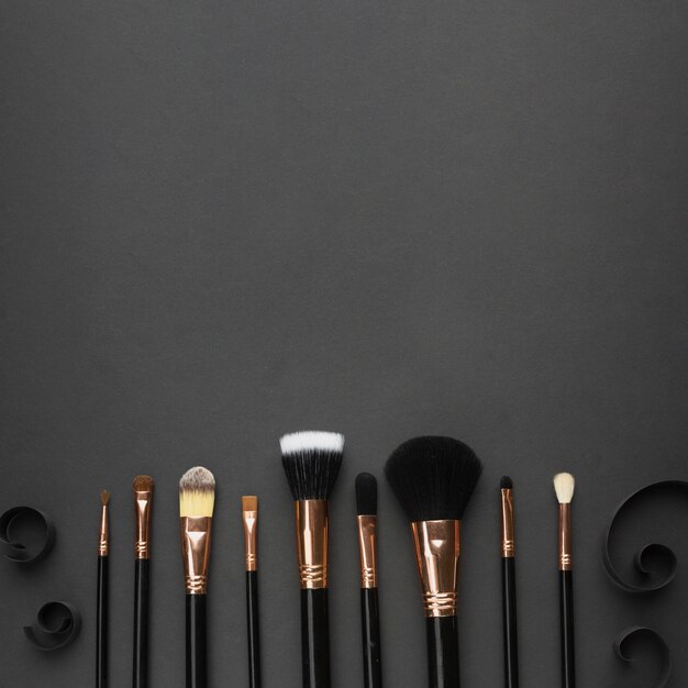 Flat lay frame with make-up brushes and black background