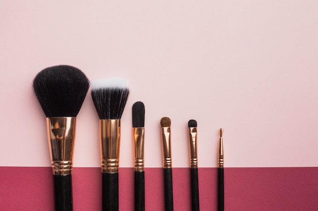 Flat lay frame with make-up brushes and pink background