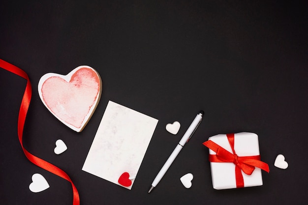 Flat lay frame with red ribbon and black background