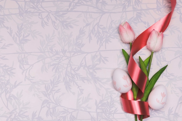 Foto gratuita cornice piatta con tulipani e nastro rosso