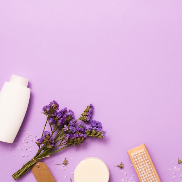 Flat lay frame with white bottle and lilac flower