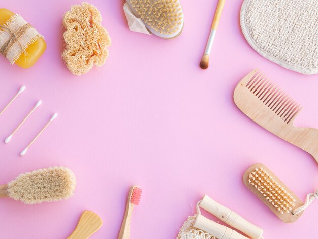 Flat lay frame with wooden items on pink background