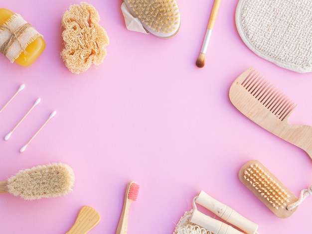 Flat lay frame with wooden items on pink background