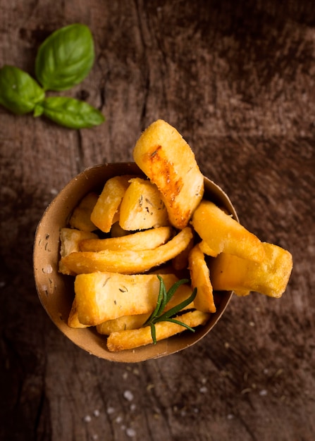 Flat lay of french fries in bowl with herbs
