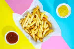 Free photo flat lay of french fries on colorful background