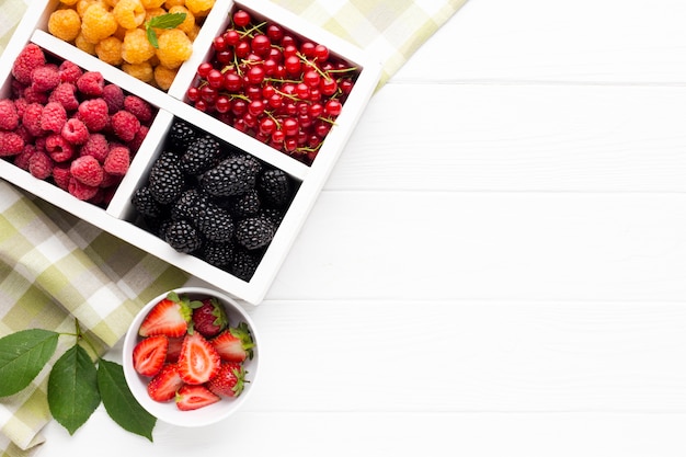 Free photo flat-lay fresh berries and fruits with copy space