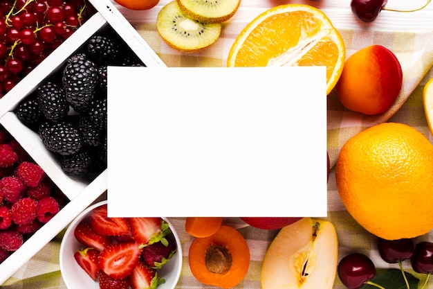 Free photo flat-lay fresh berries and fruits with paper