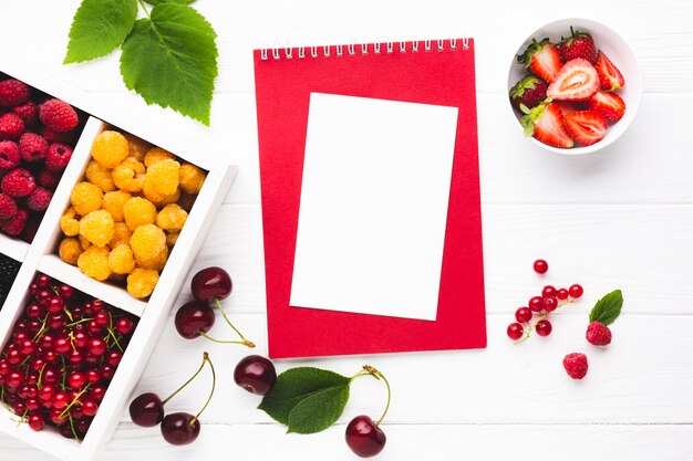 Flat-lay fresh berries with notepad