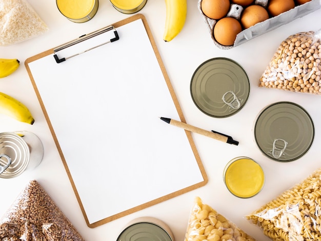 Flat lay of fresh provisions for donation with notepad