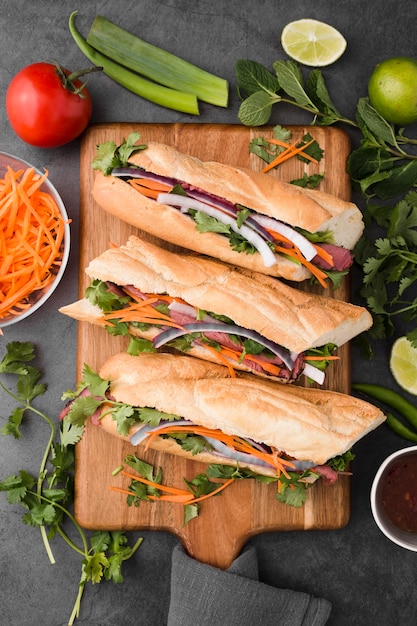 Flat lay of fresh sandwiches on chopping board