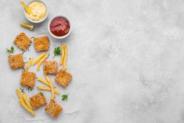 Flat lay of fried chicken nuggets with french fries and copy space