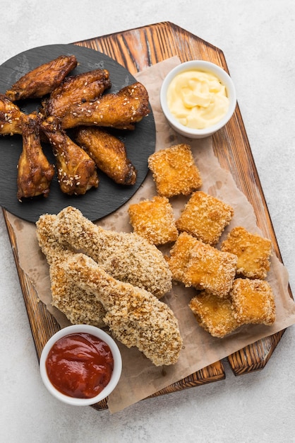 Flat lay of fried chicken and nuggets with two different sauces