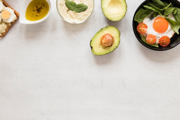 Flat lay fried egg in pan tomatoes and avocado with copy space