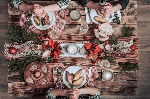 친구의 식사와 함께 마시는 평평한 손. 파티, 모임, 나무 소박한 테이블에서 함께 축하하는 사람들의 상위 뷰