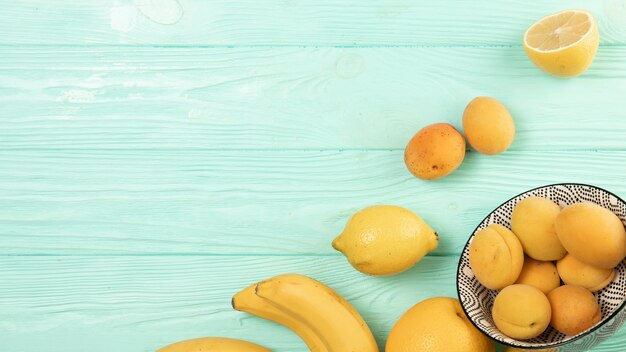 Flat lay of fruits on wooden background with copy space