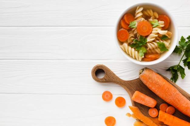 Flat lay fusilli broccoli and carrots in bowl with copy space