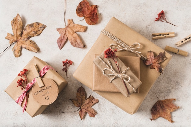 Flat lay of gift boxes with dead leaves and clothing pins