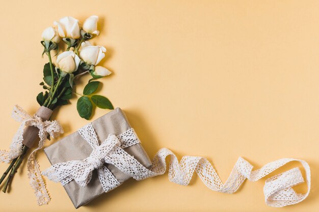 Flat lay of gift with bouquet of roses