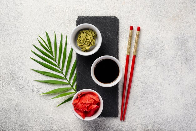 Flat lay ginger wasabi and soy sauce bowls on slate