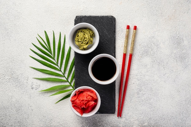 Flat lay ginger wasabi and soy sauce bowls on slate