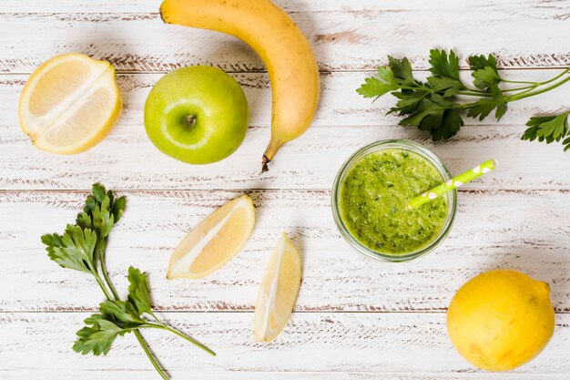 Flat lay of glass of healthy smoothie with apple and banana