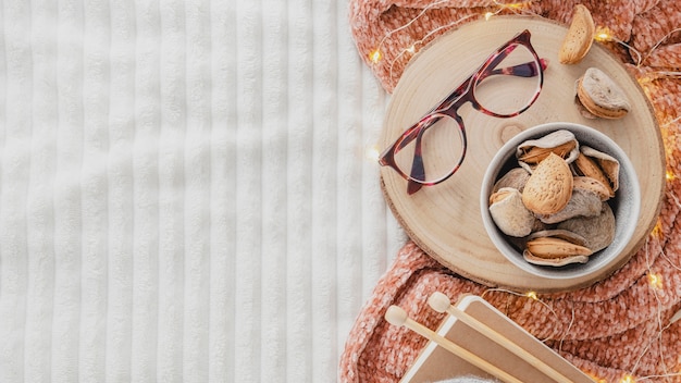 Flat lay glasses on wooden board with yarn and blanket