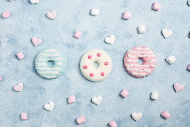 Free photo flat lay of glazed doughnuts with marshmallow and hearts