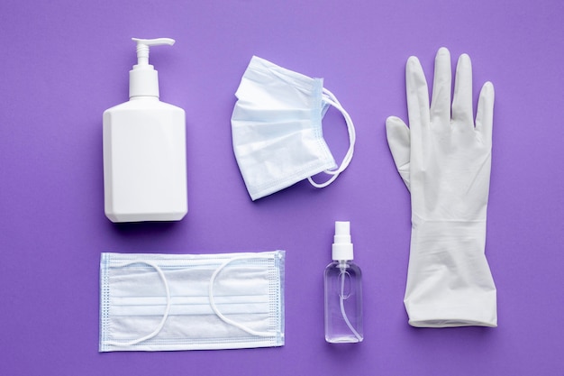 Free photo flat lay of glove with medical masks and liquid soap bottle