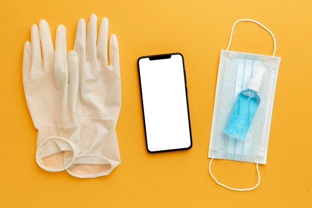 Flat lay of gloves with smartphone and hand sanitizer