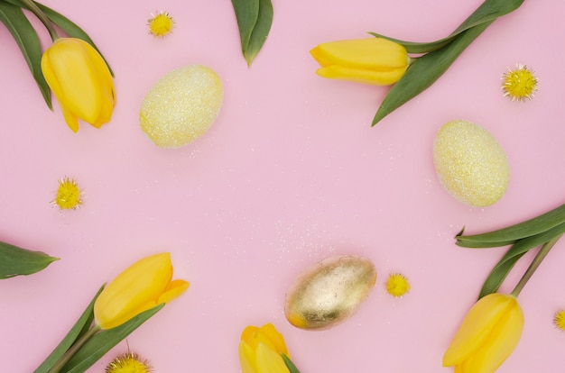 Плоская кладка золотого пасхального яйца с тюльпанами и одуванчиками