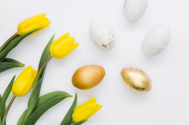 Flat lay of golden easter eggs with flowers