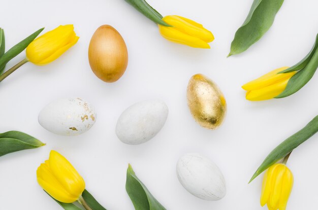 Flat lay of golden easter eggs with tulips