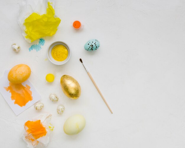 Flat lay of golden egg for easter and paint with brush