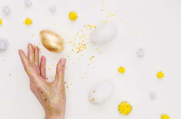 Flat lay of golden egg for easter with glitter and dandelions