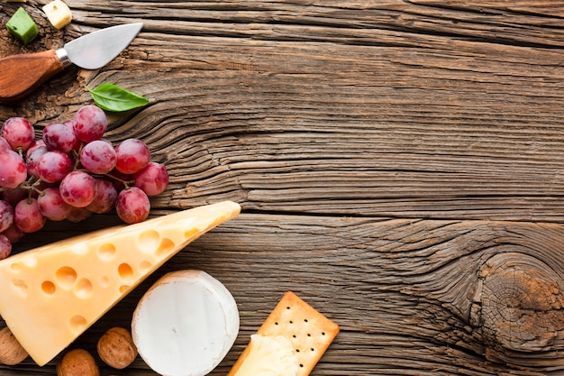 Flat lay grapes emmental and cheese knife with copy space