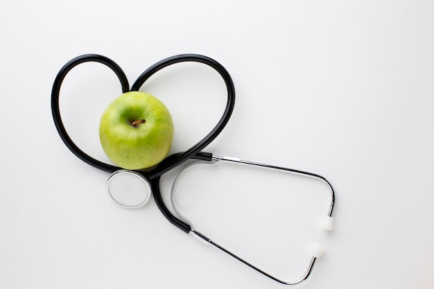 Flat lay green apple and stethoscope