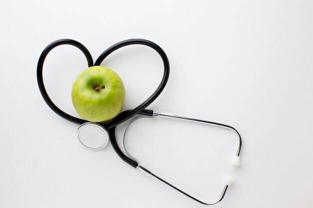 Flat lay green apple and stethoscope