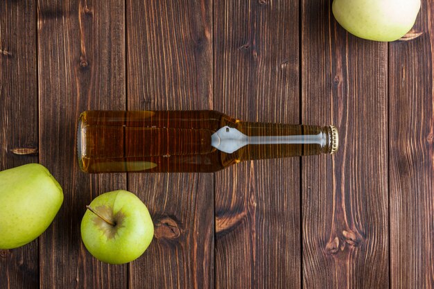 Flat lay green apples with apple juice on wooden background. horizontal space for text