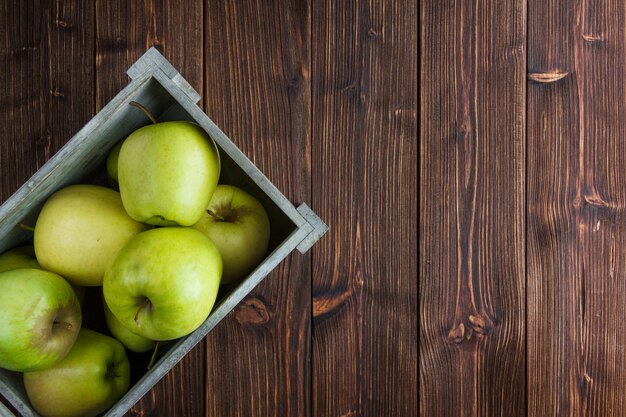 Flat lay green apples in wooden box on wooden background. horizontal free space for your text