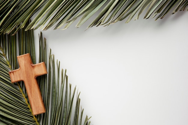 Flat lay green leaves and cross arrangement