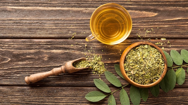 Free photo flat lay green leaves and cup of tea