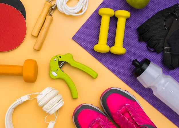 Flat lay of hand gripper with headphones and weights