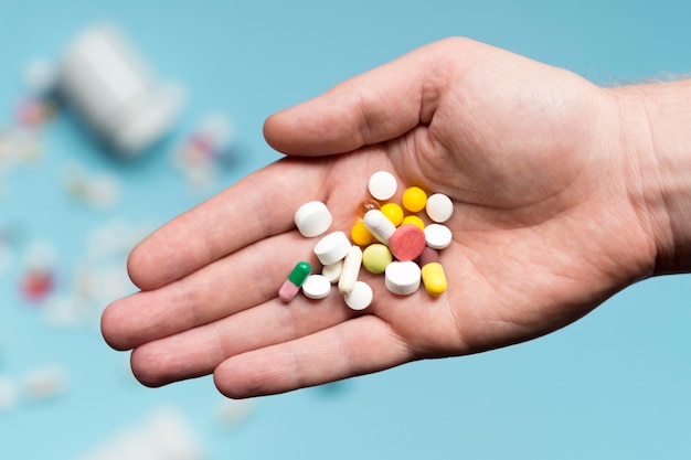 Flat lay of hand holding assortment of pills