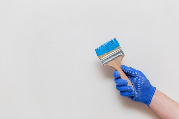 flat lay of hand holding blue paint brush