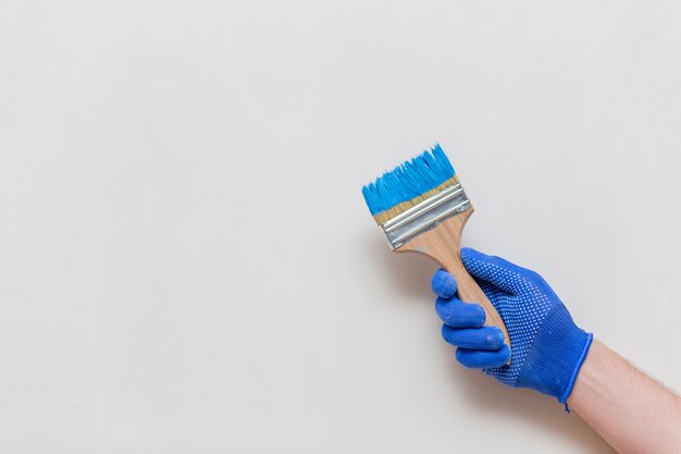 Flat lay of hand holding blue paint brush